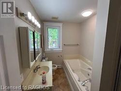 Bathroom with vanity, toilet, and a tub to relax in - 