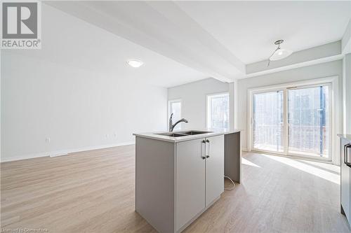 Kitchen featuring gray cabinets, sink, an island with sink, and light hardwood / wood-style floors - 155 Equestrian Way Unit# 60, Cambridge, ON - Indoor