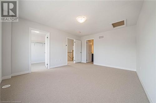 Unfurnished bedroom featuring light colored carpet, a spacious closet, and a closet - 155 Equestrian Way Unit# 60, Cambridge, ON - Indoor Photo Showing Other Room