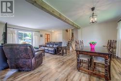 Living room with beamed ceiling, a chandelier, and light wood-type flooring - 