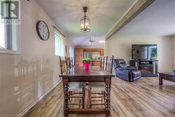 Dining area featuring beamed ceiling, a notable chandelier, and light wood-type flooring - 