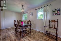 Dining area with wood-type flooring, an inviting chandelier, and a wealth of natural light - 