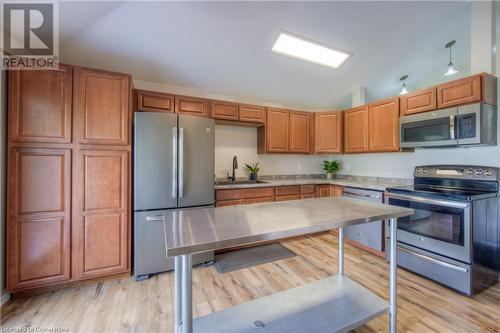 Kitchen featuring appliances with stainless steel finishes, light wood-type flooring, lofted ceiling, and sink - 8 Gerrard Avenue, Cambridge, ON - Indoor Photo Showing Kitchen