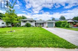 View of front facade featuring a garage and a front lawn - 