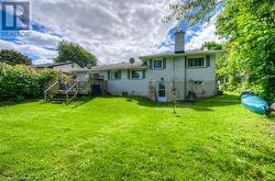 Rear view of house featuring a deck and a yard - 