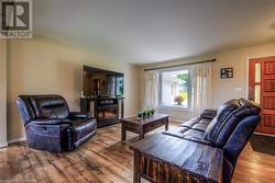 Living room with a fireplace and wood-type flooring - 