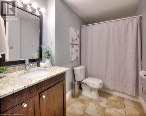 Bathroom featuring tile patterned floors, vanity, and toilet - 276 Eiwo Court Unit# 105, Waterloo, ON - Indoor Photo Showing Bathroom