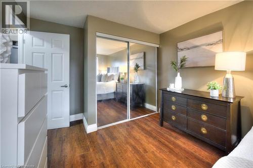 Unfurnished bedroom with dark hardwood / wood-style flooring and a closet - 276 Eiwo Court Unit# 105, Waterloo, ON - Indoor