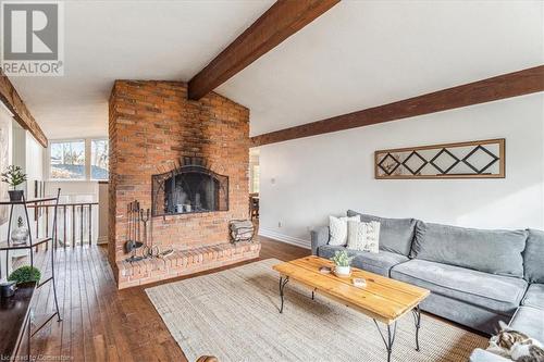 Living room featuring lofted ceiling with beams and wood burning fireplace - 756 King Road, Burlington, ON - Indoor Photo Showing Living Room With Fireplace