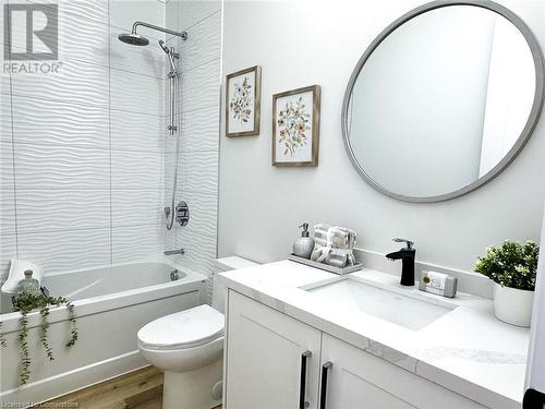 Full bathroom featuring toilet, vanity, tiled shower / bath combo, and hardwood / wood-style flooring - 53 Giles Street, London, ON - Indoor Photo Showing Bathroom