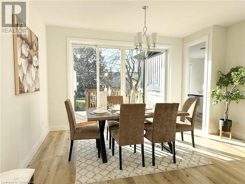 Dining room with light wood-type flooring, a healthy amount of sunlight, and a notable chandelier - 53 Giles Street, London, ON - Indoor Photo Showing Dining Room