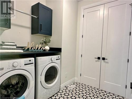 Clothes washing area with cabinets and washing machine and dryer - 53 Giles Street, London, ON - Indoor Photo Showing Laundry Room