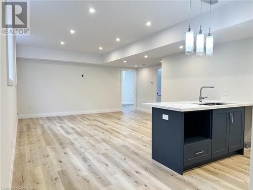 Kitchen featuring light wood-type flooring, decorative light fixtures, and sink - 53 Giles Street, London, ON - Indoor Photo Showing Kitchen