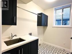 Laundry area with sink, cabinets, and washer hookup - 