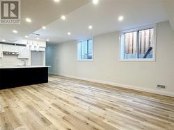 Unfurnished living room with sink and light hardwood / wood-style floors - 