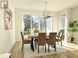 Dining room featuring a chandelier, a healthy amount of sunlight, and light wood-type flooring - 