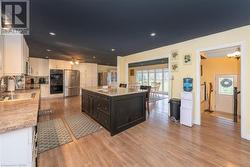 Kitchen featuring appliances with stainless steel finishes, sink, white cabinets, light hardwood / wood-style floors, and a kitchen island - 