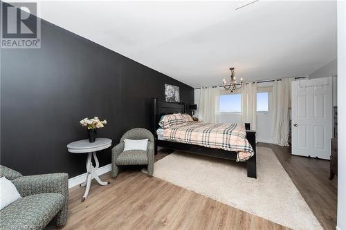 Bedroom featuring lofted ceiling, hardwood / wood-style flooring, and a notable chandelier - 9202 9Th Line, Halton Hills, ON - Indoor Photo Showing Bedroom