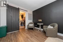 Sitting room with a barn door, a chandelier, and wood-type flooring - 