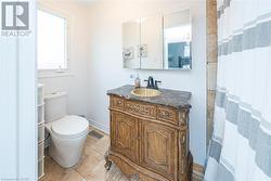 Bathroom with toilet, vanity, and tile patterned floors - 