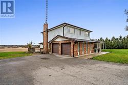 View of front of home featuring covered porch, a garage, and a front lawn - 