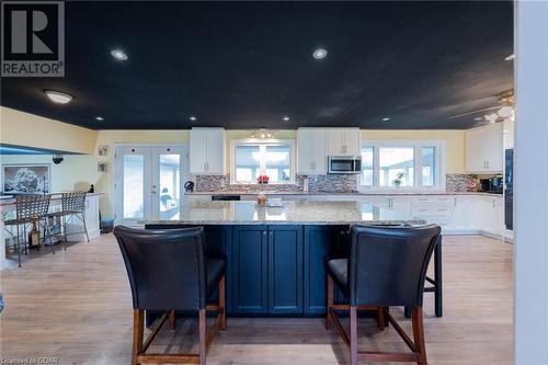 Kitchen featuring decorative backsplash, french doors, light hardwood / wood-style floors, and white cabinetry - 9202 9Th Line, Halton Hills, ON - Indoor