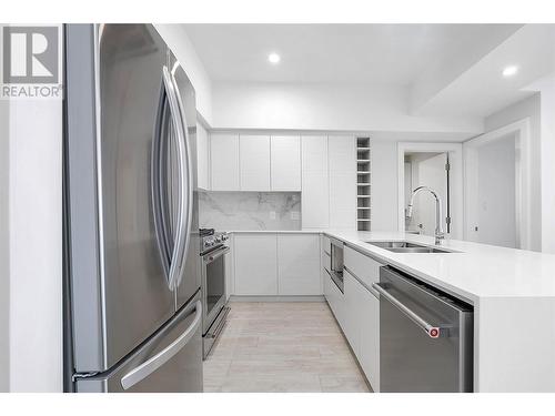 The ceiling is digitally staged; repairs will be completed before closing - 1925 Enterprise Way Unit# 205, Kelowna, BC - Indoor Photo Showing Kitchen With Stainless Steel Kitchen With Double Sink With Upgraded Kitchen