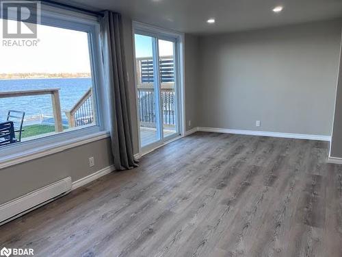 Spare room featuring a water view, wood-type flooring, and a baseboard heating unit - 80 Ridley Street, Prince Edward County, ON - Indoor Photo Showing Other Room