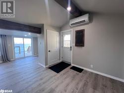 Foyer featuring light hardwood / wood-style floors, vaulted ceiling, and a wall mounted AC - 