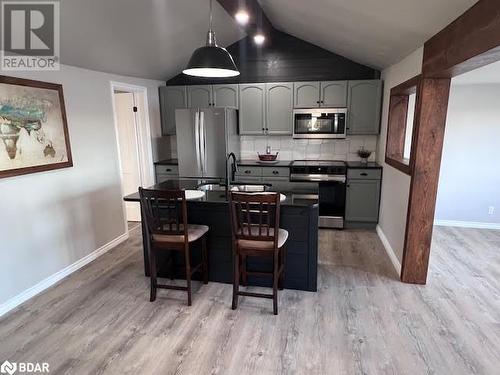 Kitchen featuring appliances with stainless steel finishes, tasteful backsplash, vaulted ceiling, sink, and hanging light fixtures - 80 Ridley Street, Prince Edward County, ON - Indoor Photo Showing Kitchen