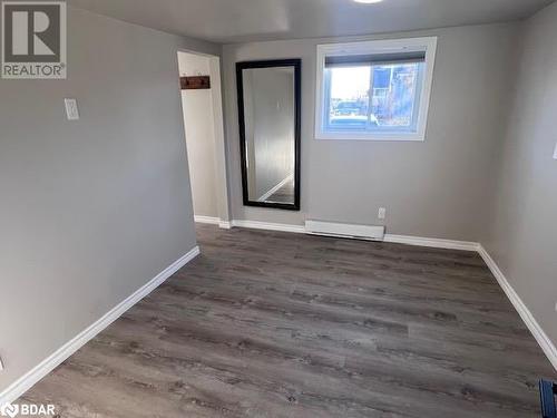 Unfurnished room featuring dark hardwood / wood-style floors and a baseboard radiator - 80 Ridley Street, Prince Edward County, ON - Indoor Photo Showing Other Room