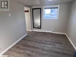 Unfurnished room featuring dark hardwood / wood-style floors and a baseboard radiator - 