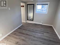 Empty room featuring baseboard heating and dark wood-type flooring - 