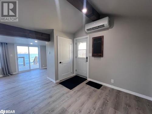 Kitchen with backsplash, light hardwood / wood-style floors, lofted ceiling, white cabinets, and appliances with stainless steel finishes - 80 Ridley Street, Prince Edward County, ON - Indoor Photo Showing Other Room