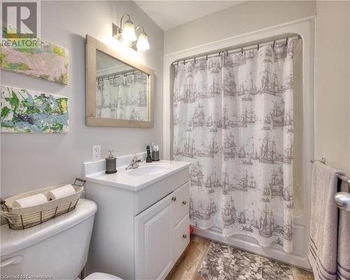 Full bathroom with hardwood / wood-style floors, shower / bath combination with curtain, toilet, and vanity - 524 Krug Street, Kitchener, ON - Indoor Photo Showing Bathroom