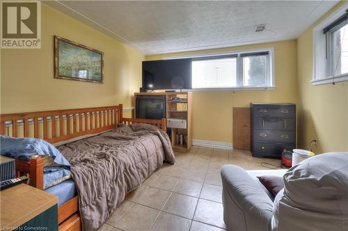 Tiled bedroom with a textured ceiling and multiple windows - 524 Krug Street, Kitchener, ON - Indoor Photo Showing Bedroom