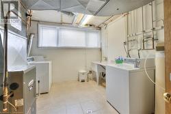 Laundry area with washing machine and clothes dryer and light tile patterned floors - 