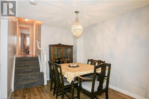 Dining space with a notable chandelier, dark hardwood / wood-style flooring, and a textured ceiling - 220 Bankside Drive, Kitchener, ON - Indoor Photo Showing Dining Room