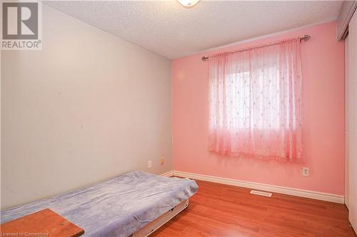 Bedroom with light hardwood / wood-style flooring and a textured ceiling - 220 Bankside Drive, Kitchener, ON - Indoor Photo Showing Bedroom