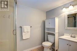 Bathroom featuring tile patterned floors, vanity, toilet, and an enclosed shower - 