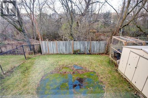 View of yard with green space behind. No rear neighbours. A plastic pool used left a mark on the grass. - 220 Bankside Drive, Kitchener, ON - Outdoor