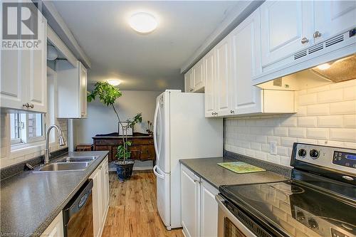 Kitchen with exhaust hood, sink, white cabinetry, and stainless steel electric range - 220 Bankside Drive, Kitchener, ON - Indoor Photo Showing Kitchen With Double Sink