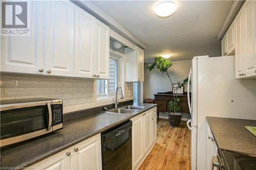 Kitchen featuring white cabinetry, dishwasher, light hardwood / wood-style flooring, and sink - 220 Bankside Drive, Kitchener, ON - Indoor Photo Showing Kitchen With Double Sink