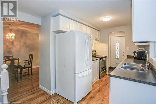 Kitchen featuring stainless steel range with electric stovetop, white cabinets, white refrigerator, sink, and light hardwood / wood-style floors - 220 Bankside Drive, Kitchener, ON - Indoor Photo Showing Kitchen With Double Sink