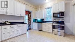 Kitchen with white cabinetry and stainless steel appliances - 