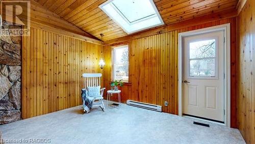 Living area featuring a wealth of natural light, a baseboard heating unit, and wood walls - 550 10Th Street A West, Owen Sound, ON - Indoor Photo Showing Other Room