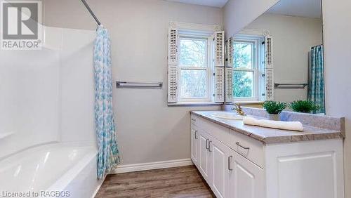 Bathroom featuring hardwood / wood-style floors, vanity, and shower / tub combo with curtain - 550 10Th Street A West, Owen Sound, ON - Indoor Photo Showing Bathroom