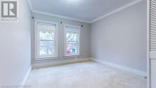 Empty room featuring lofted ceiling, light colored carpet, a textured ceiling, and ornamental molding - 550 10Th Street A West, Owen Sound, ON - Indoor Photo Showing Other Room