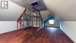 Additional living space with dark wood-type flooring and vaulted ceiling - 