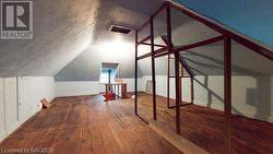 Additional living space with dark wood-type flooring and vaulted ceiling - 